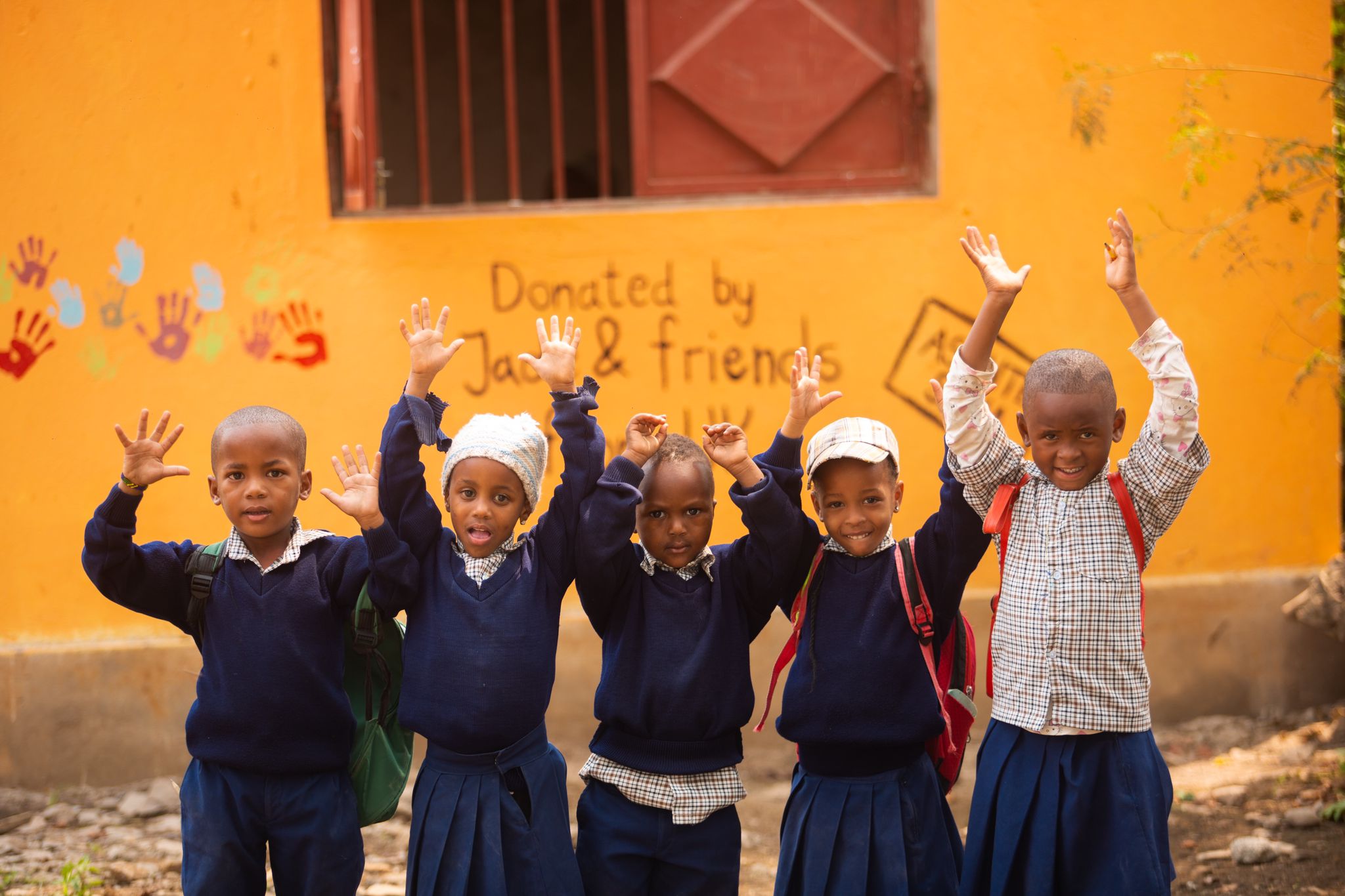 Children raising their hands at a school in Tanzania