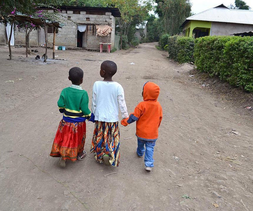 Tanzanian children walking to school holding hands